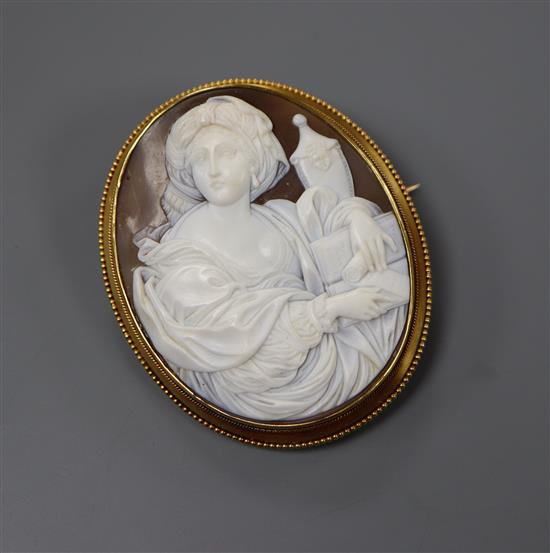 A cased yellow metal and carved oval cameo brooch, decorated with the figure of a lady with an urn, 57mm.